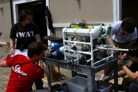 The ROV and tether are loaded onto a wheeled cart.